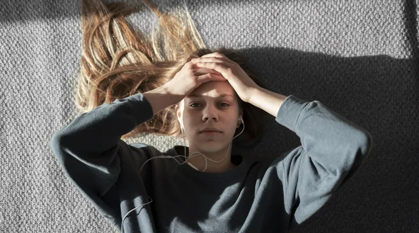 dívka poslouchá hudbu a leží zhrouceně na zemi