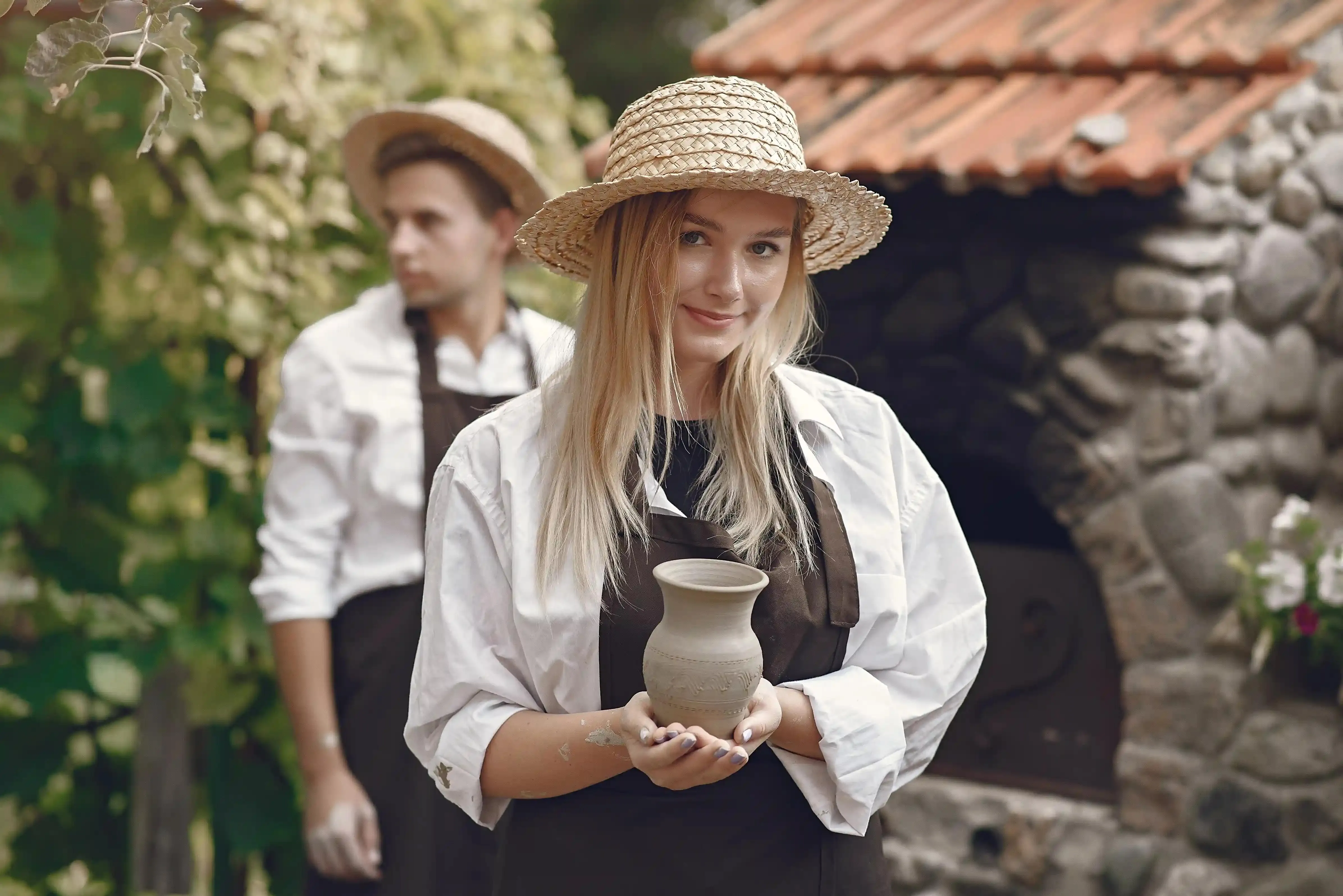 žena na workshopu tvoří vlastní vázu z hlíny