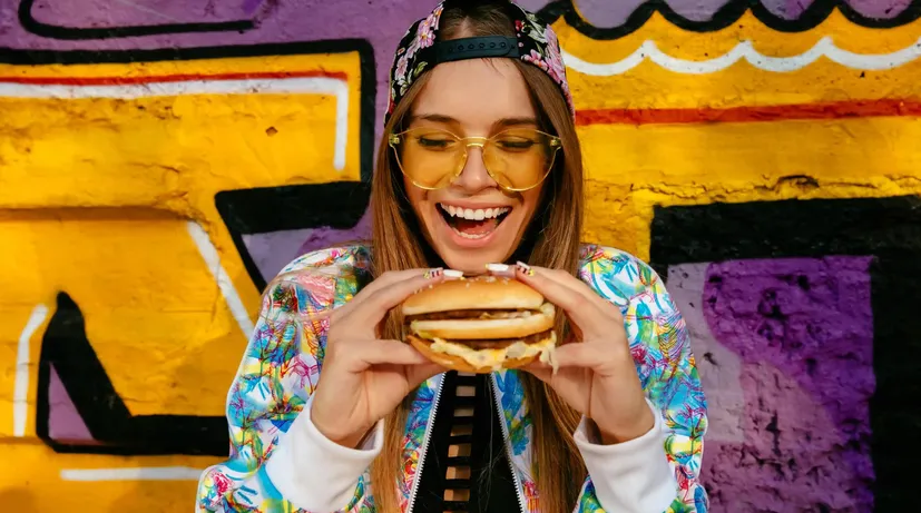 mladá dívka se chystá sníst burger na ulici