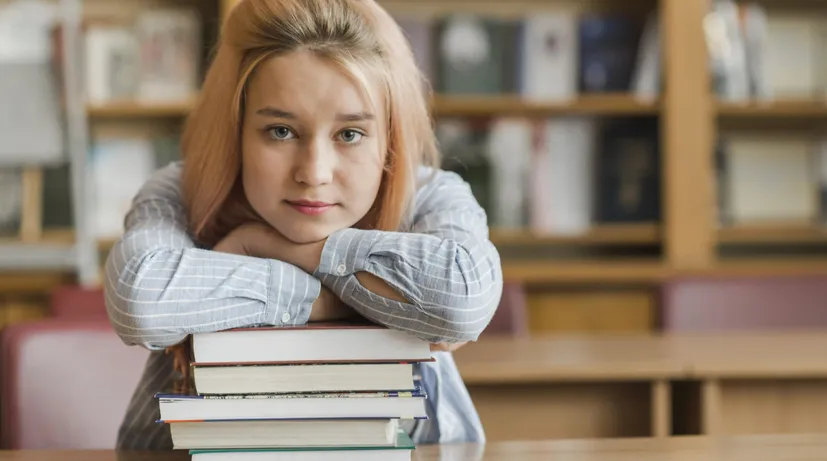 dívka s knihami ve školní lavici