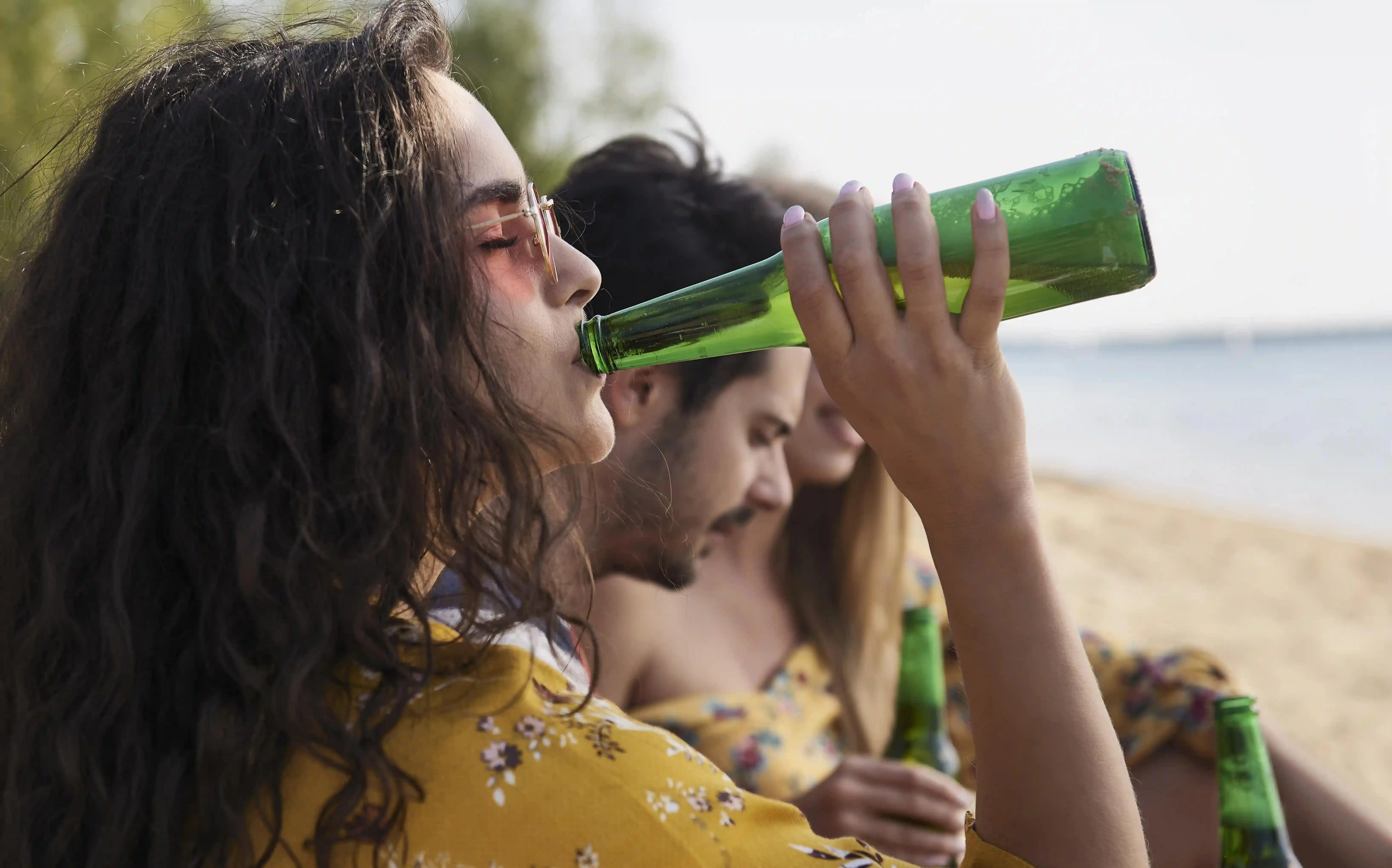 dívka si dopřává pivo na pláži