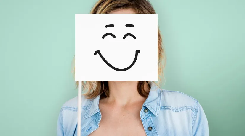 žena má před sebou vlaječku s usměvavým emotikonem