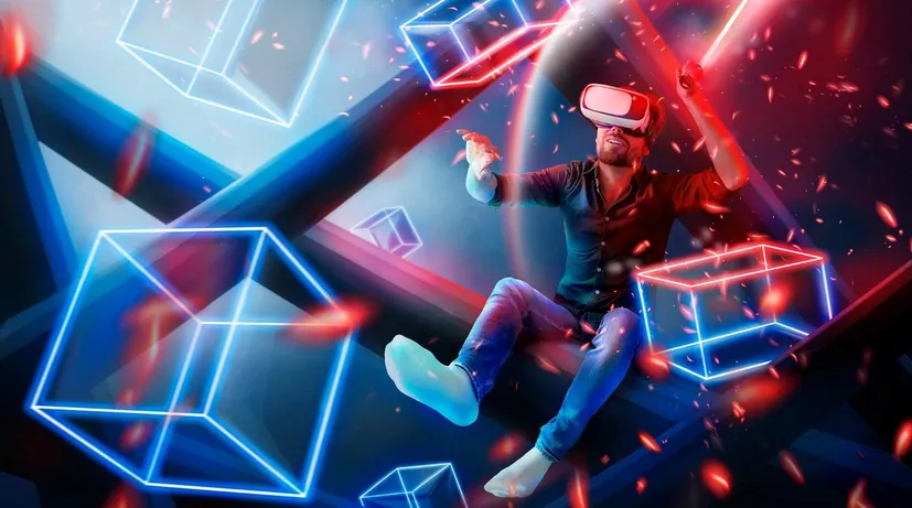 muž hrající VR v grafice barevné, kde kolem něj létají krychle