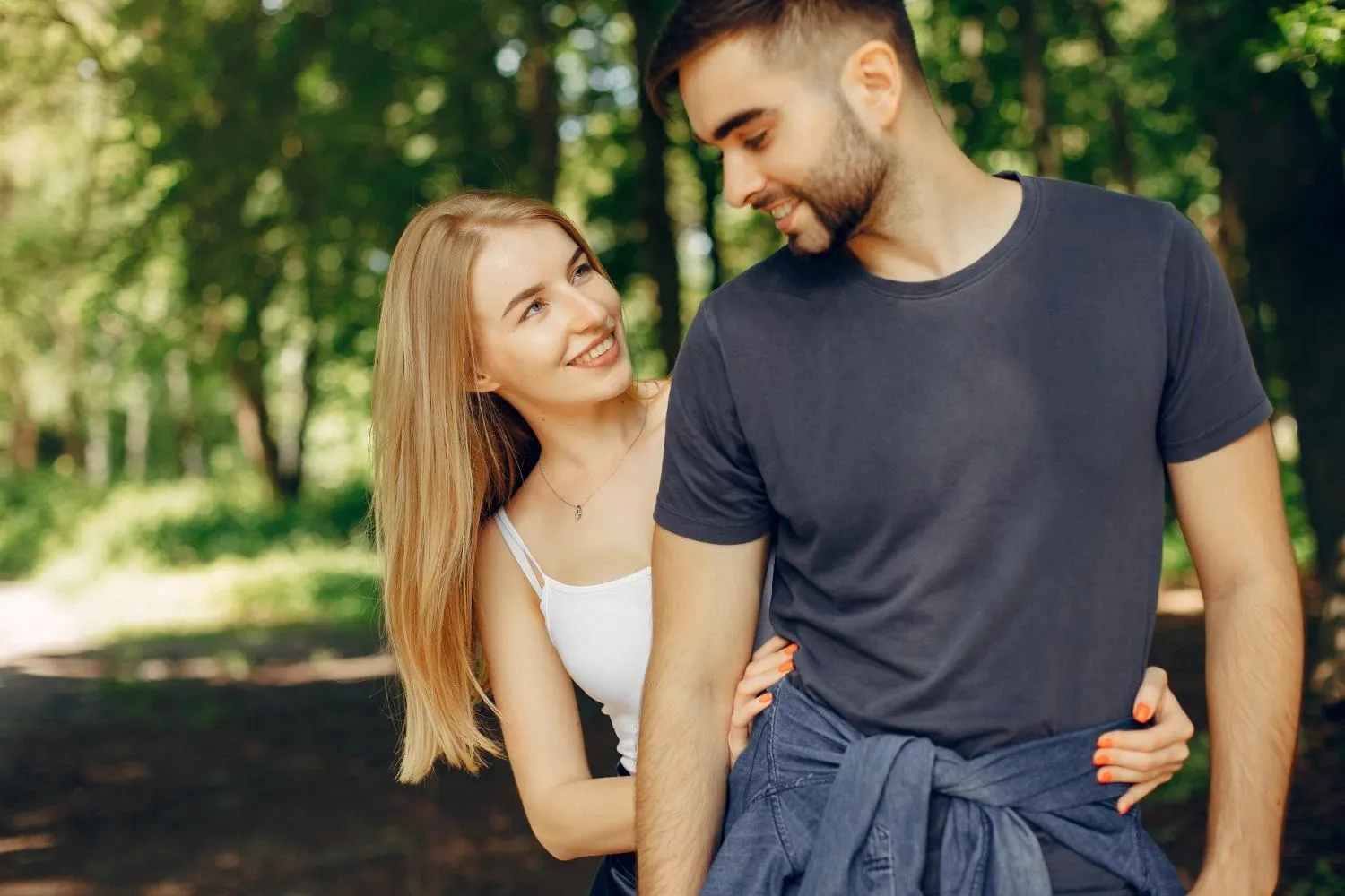 dívka s mužem, škádlí se na procházce venku v parku
