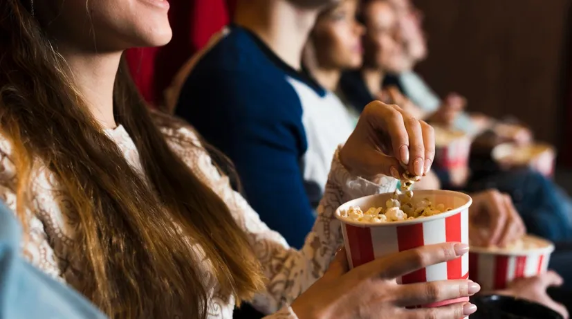 dívka jí popcorn v kině