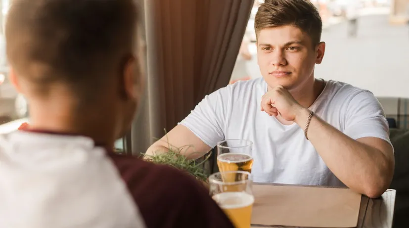 dva mladí muži v restauraci si povídají