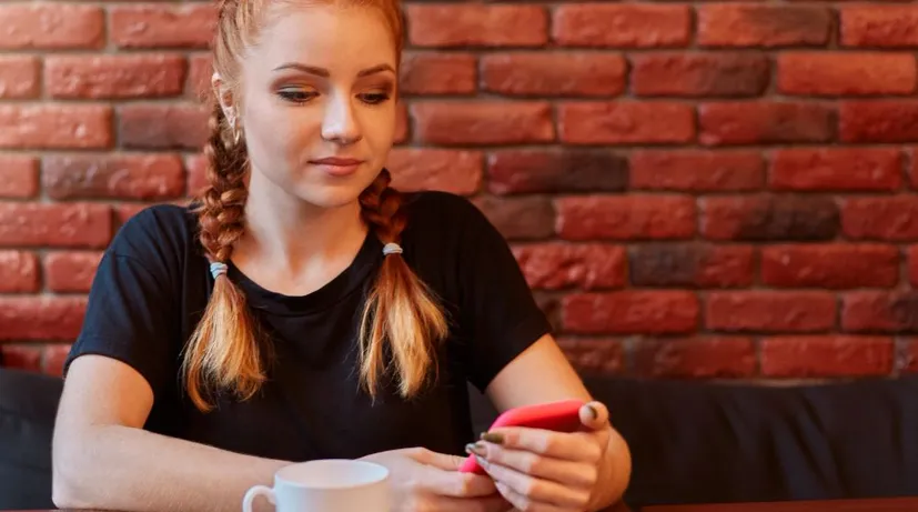dívka si s někým píše na mobilu, ale už jí to nebaví