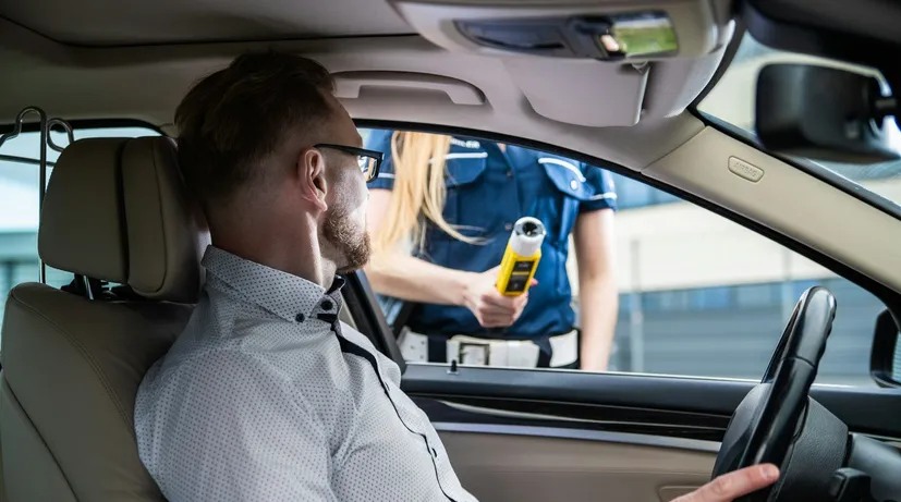 policistka jde řidiči provézt dechovou zkoušku na alkohol
