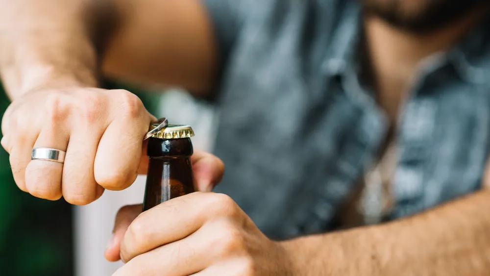 muž si otvírá pivo