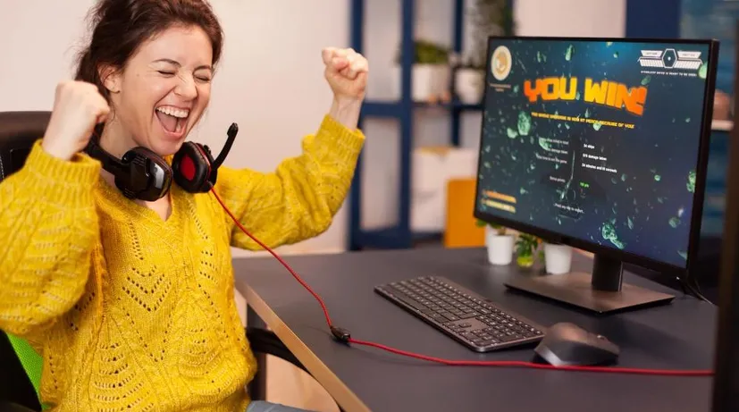 žena, která hraje nějakou hru na počítači a vyhrává