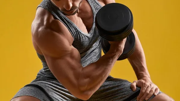 muž cvičí s činkou biceps ve fitku